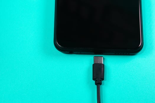 mobile phone connected to a charger on white background photo