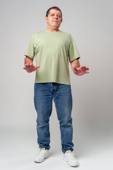 An older man standing confidently in casual attire, wearing a green shirt photo