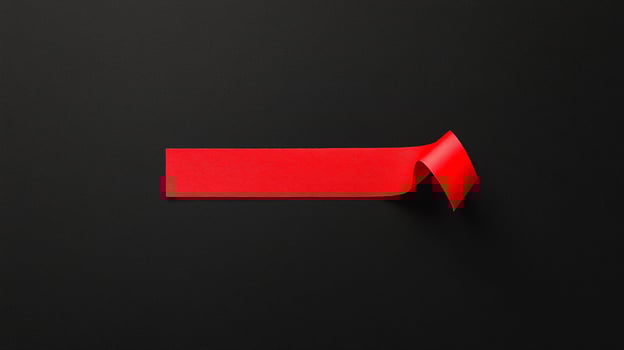 A red piece of paper is placed on a black background photo