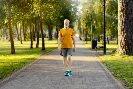 Senior man walking in park enjoying healthy lifestyle photo
