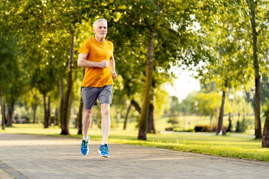 Senior man jogging in park maintaining healthy lifestyle photo