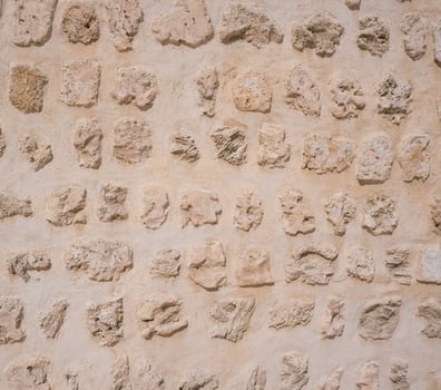 Traditional stone, coral and adobe wall in Sharjah emirate in the United Arab Emirates. Such hand plastered walls were made for centuries in the Arabian Gulf with materials from the desert and sea. photo