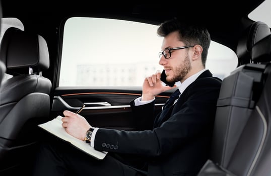 Important Call. Side view of focused businessman planning his day and talking on cell phone, going to office by car photo