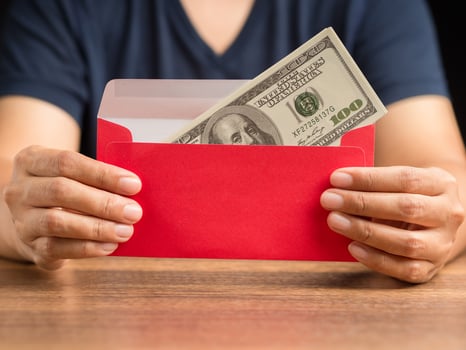 Man in casual holding a red envelope with money photo