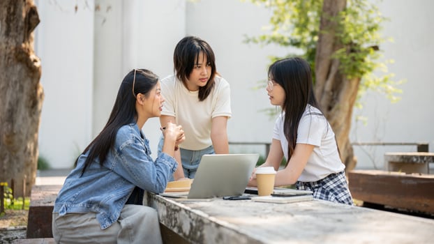 A group of young Asian female college students is focused on discussing a project. photo