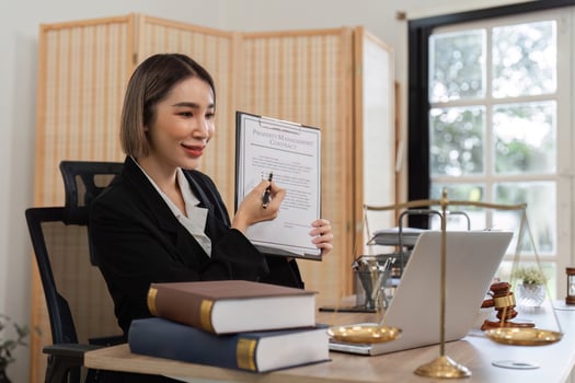 Young Female Lawyer Introducing Business Contract Law in Modern Office Setting with Legal Documents and Laptop photo