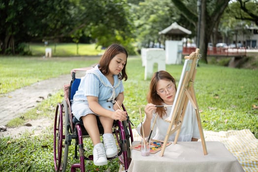 Close Friends, Disabled Young Women Drawing Together Outdoors in a Park on a Sunny Day, Embracing Creativity and Friendship photo