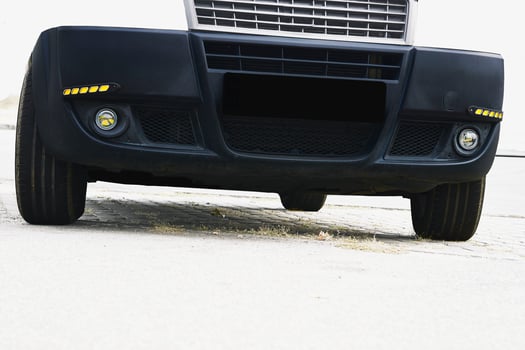Fog light and LED side lights on black bumper in white photo