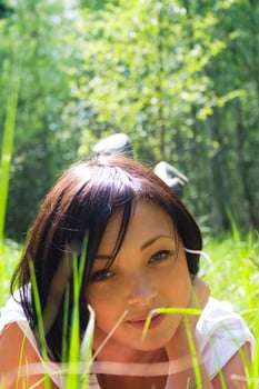 Beautiful irl laying on a field among fresh grass photo
