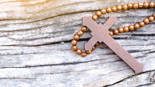 Dark red wooden cross on wooden background symbolizing the spread of Jesus Christs love among Christians reflecting faith devotion and the importance of Christian teachings. photo