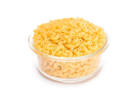Uncooked Chifferi Rigati Pasta in Glass Jar Isolated on White Background. Fat and Unhealthy Food. Classic Dry Macaroni. Italian Culture and Cuisine. Raw Pasta - Isolation photo