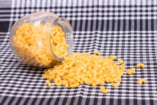 Scattered Uncooked Chifferi Rigati Pasta on Black Checkered Towel. Fat and Unhealthy Food. Classic Dry Macaroni. Italian Culture and Cuisine. Raw Pasta photo