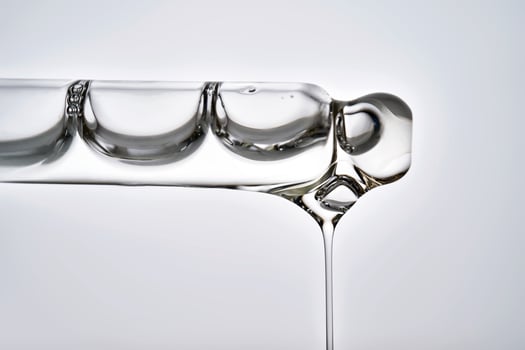 Dropper pipette with delicious serum with drop close-up. photo