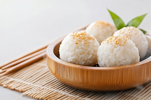Steaming rice balls served in a wooden bowl with sesame seeds and a gentle traditional atmosphere photo