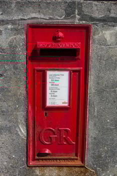 A red post box on a wall photo