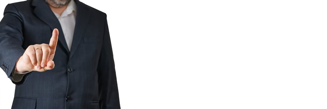A businessman in a tailored dark suit and white shirt stands confidently, pointing at an invisible screen. The bright white background highlights his professional demeanor and authority. photo