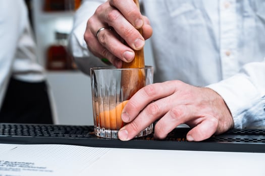 Cocktail preparation and alcohol tasting at a bustling bar in the evening photo