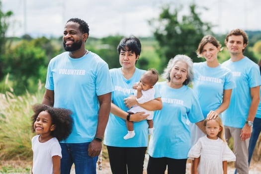 group of people wearing blue volunteer t-shirts are standing together photo