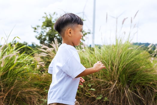 young boy is running through a field of tall grass photo