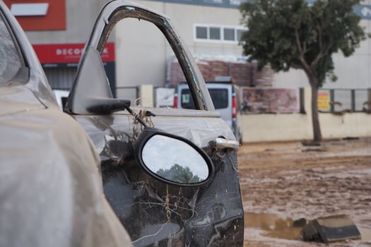 VALENCIA, SPAIN OCTOBER 31, 2024. Wrecked car covered in mud in the city of Valencia, Spain, demonstrating the devastating effects of flooding photo