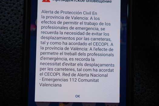VALENCIA, SPAIN OCTOBER 31, 2024. Smartphone displaying an emergency alert message from civil protection authorities advising against road travel in Valencia, Spain, due to flooding photo