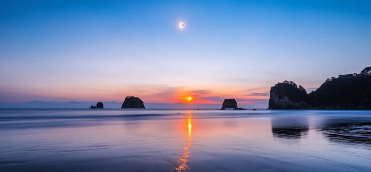 Serene beach at sunset with a crescent moon and gentle waves. photo