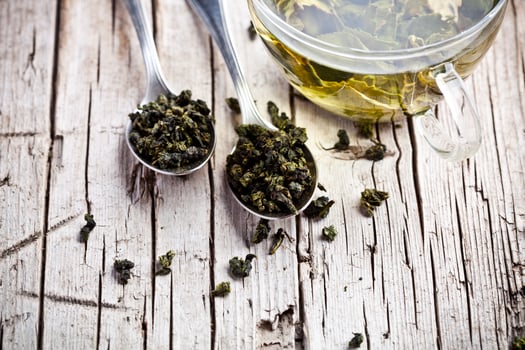 cup of green tea and spoons photo