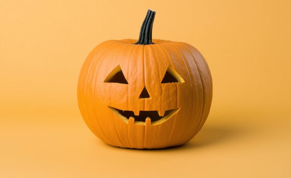jack o lantern pumpkin with carved face on orange background photo