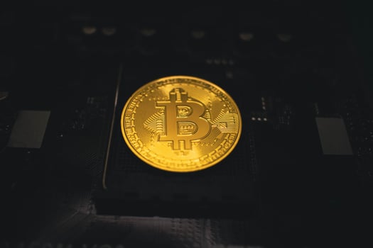 Golden Bitcoin Coin on a Dark Circuit Board. photo