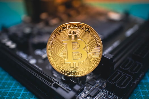 Golden Bitcoin Coin Standing on Circuit Board. photo