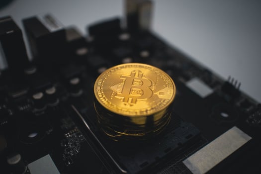 Golden Bitcoin Stack on a Dark Computer Circuit Board. photo