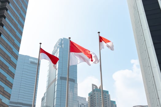 Indonesian flags waving in the wind in front of modern office building. After edits. photo