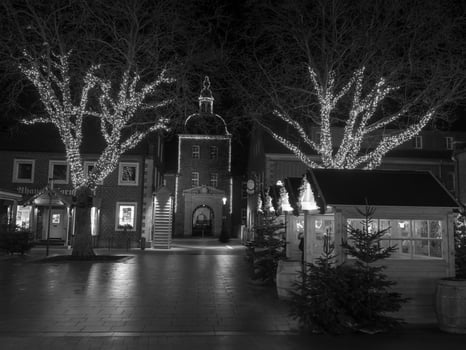 A black and white photo of a town square at night