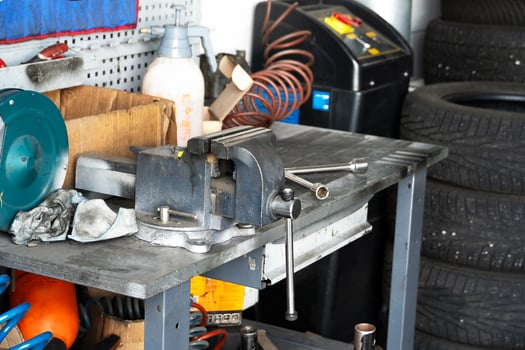Mess on a working table with metallic tools and metal vice, tires pressure, garage workshop photo