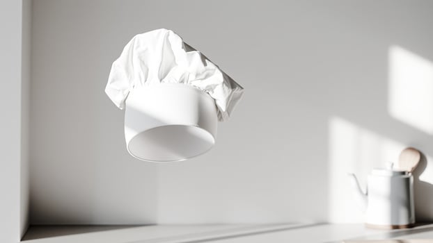 white chef's hat floating against a plain white background photo