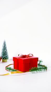 festive red gift box with a golden ribbon pine sprig photo