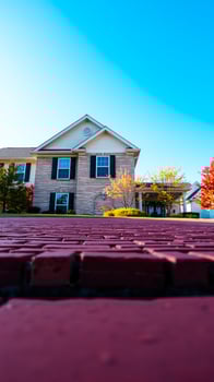 brick walkway leading a house with fall foliage photo