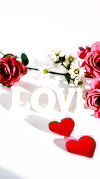 white letters love surrounded by red white flowers photo