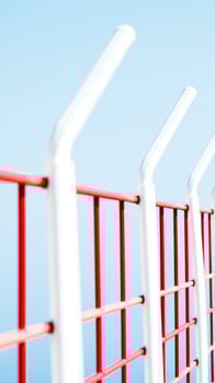 red white metal fence against a blue sky photo
