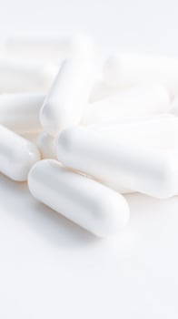 close- white capsules on a white surface photo