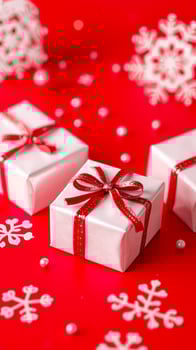 white gift boxes with red ribbons snowflake decorations on a red surface photo