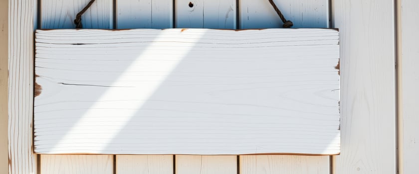 blank white wooden sign hanging on a light wood wall photo