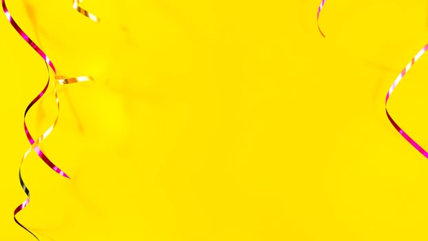bright yellow background with twirling pink gold ribbons photo