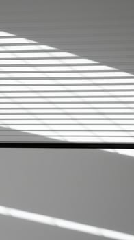 sunlight casting horizontal shadows on a white wall photo