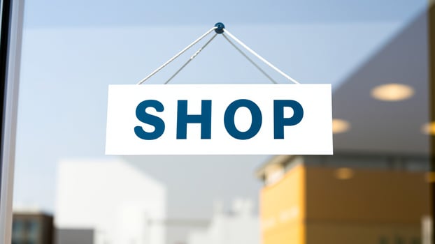 white shop sign hanging outside a store photo