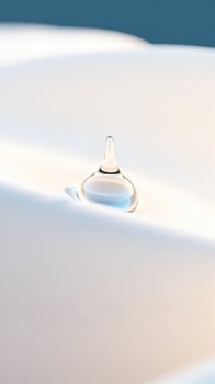 single water drop on a white surface photo