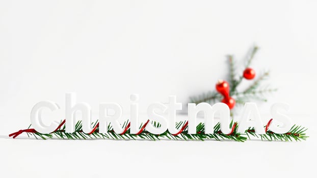 white christmas letters resting on green pine branches photo