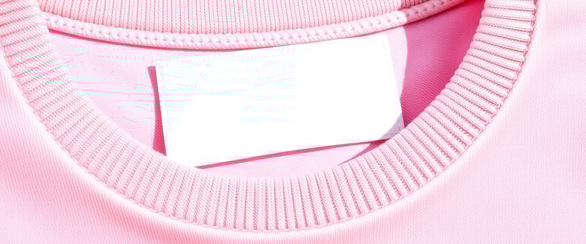 blank white label sewn into light pink fabric neckline photo