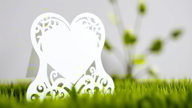 white heart-shaped card with intricate cutouts grass photo