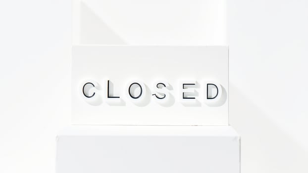 white sign with black lettering reads closed photo